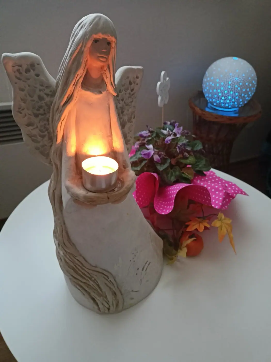 A ceramic angel holding a lit candle – a calm atmosphere for the session