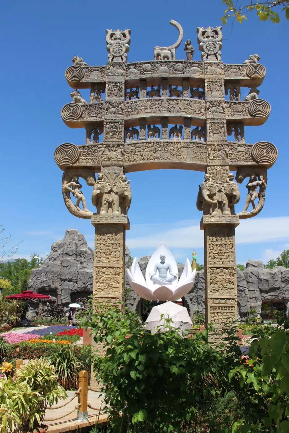 A stone gateway and a statue meditating in a lotus flower