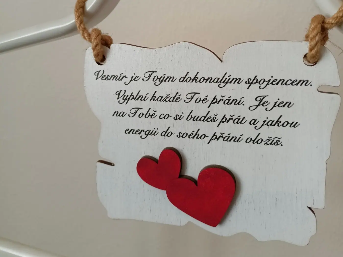 A wooden sign reading “The universe is your perfect ally…” (in Czech) with two hearts