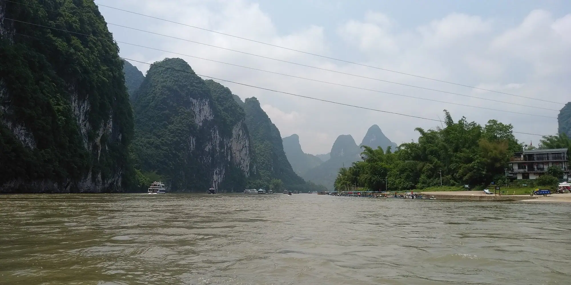 A boat on the Li River among karst hills – on the way to a client